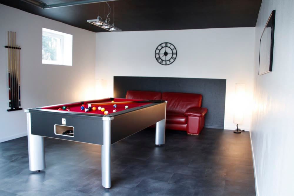 Salle de billard de La Grange d'Hélène à Siersthal avec table au tapis rouge, porte-queues et fauteuils