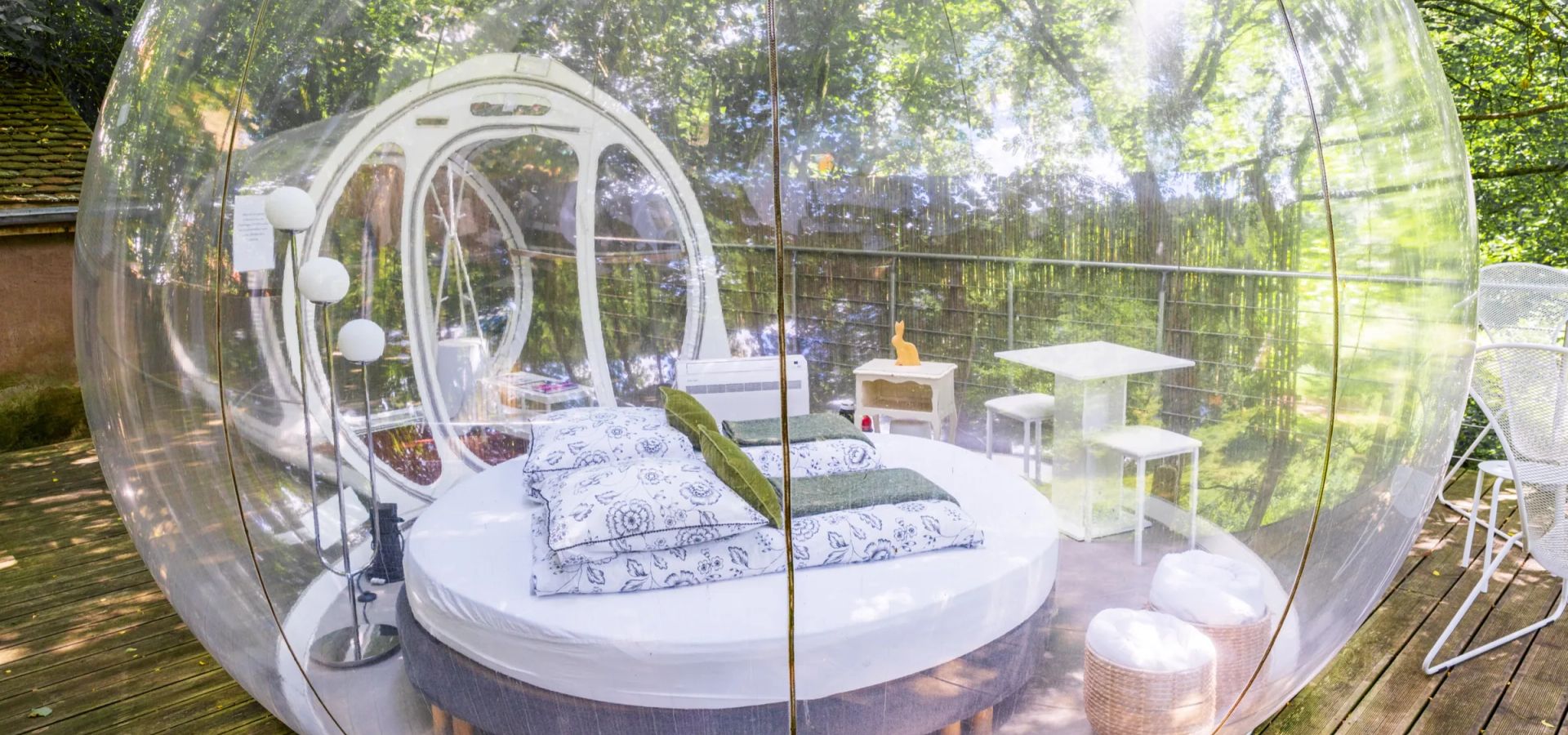 Intérieur de La Bulle avec lit rond et vue sur la forêt