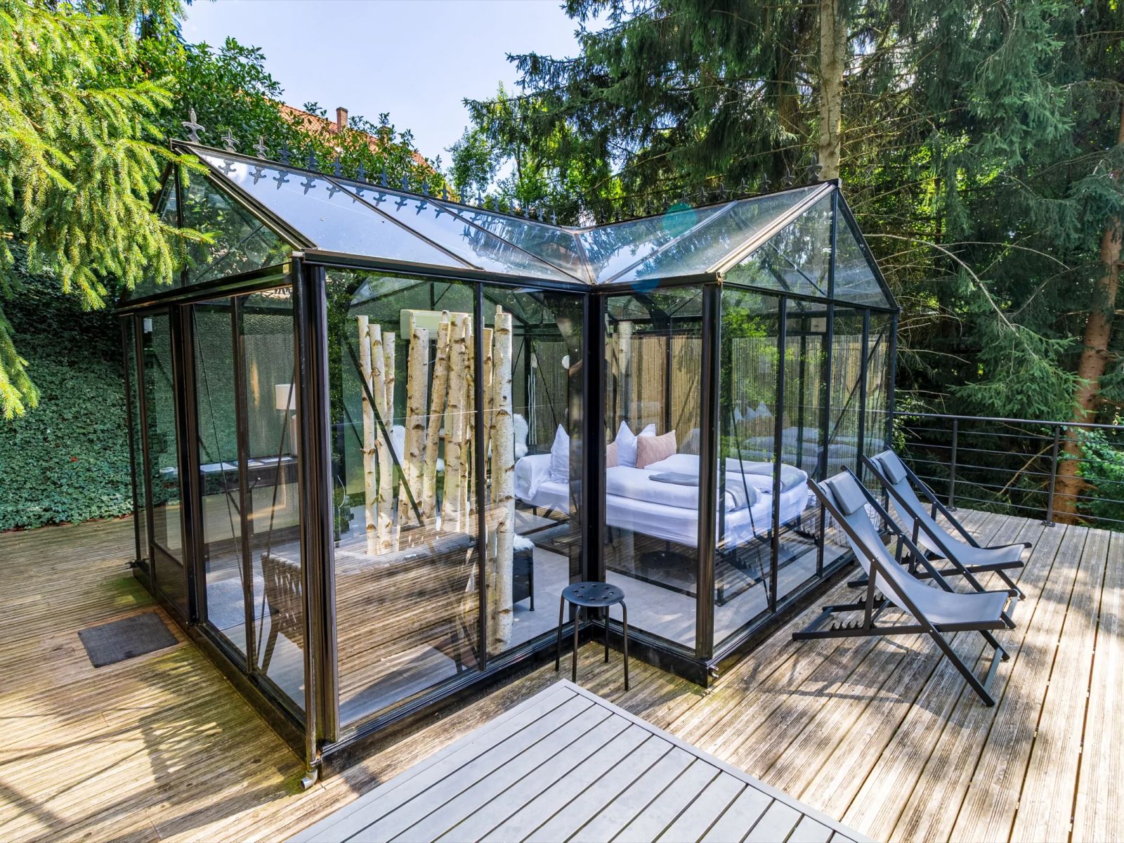 Vue d'ensemble de La Chambre de Verre entourée d'arbres et de haies de bambou