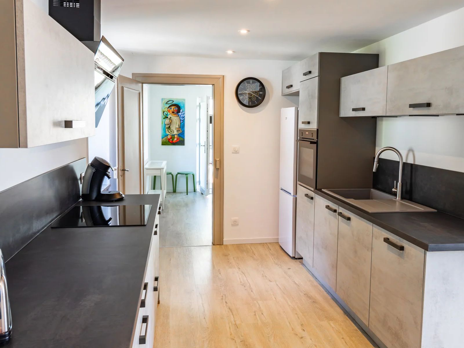 Cuisine moderne de La Petite Grange avec plaques de cuisson et réfrigérateur