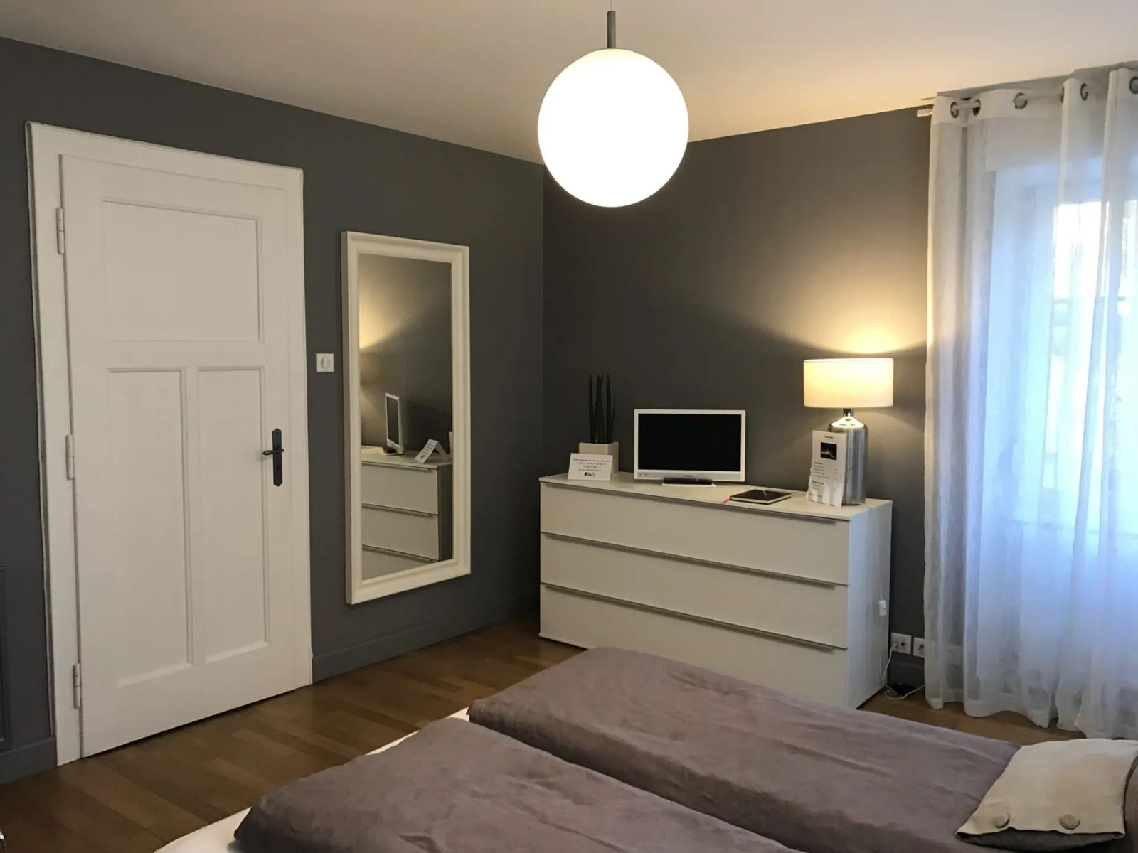 Chambre principale de La Suite avec commode, miroir et télévision
