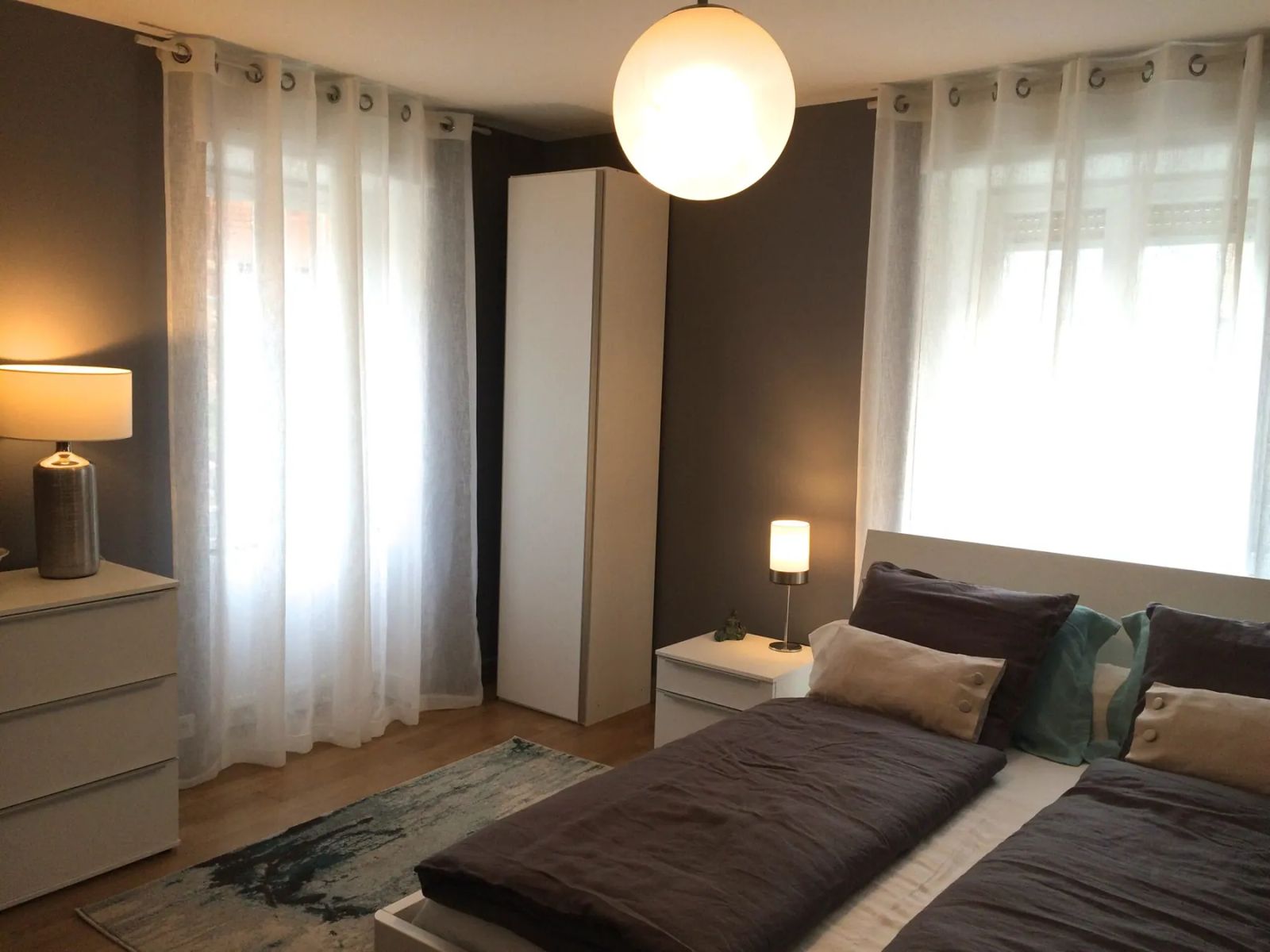 Lit double de La Suite avec linge gris et touches bleu clair