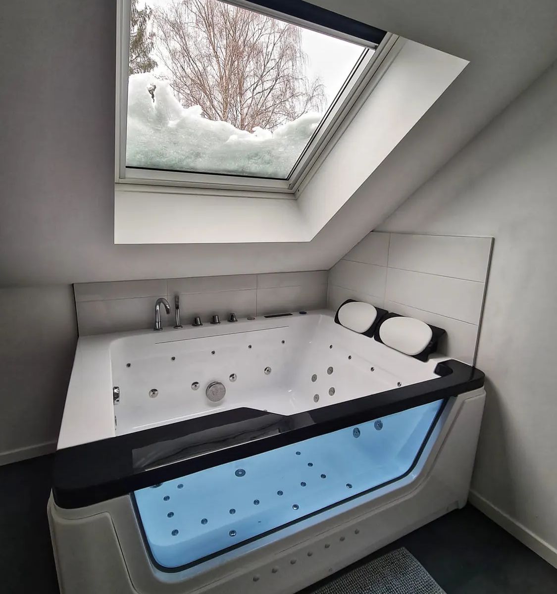 Double baignoire balnéo du Gîte de l'Alchimiste sous une fenêtre de toit